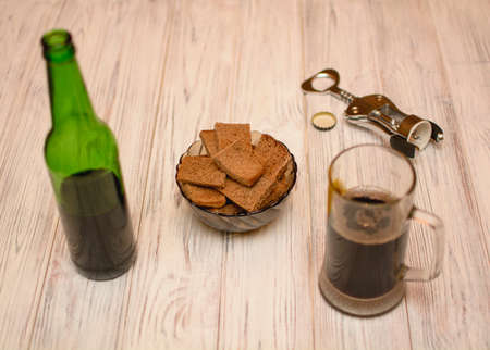Dark beer in a glass with bread croutonsの写真素材