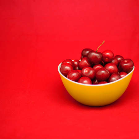 Many ripe cherries on a beautiful background in a plateの写真素材