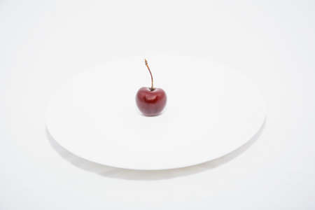 Many ripe cherries on a beautiful background in a plateの写真素材