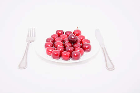 Many ripe cherries on a beautiful background in a plateの写真素材