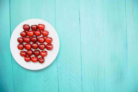 Many ripe cherries on a beautiful background in a plate