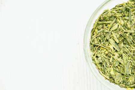Green tea in a transparent cup on a light background