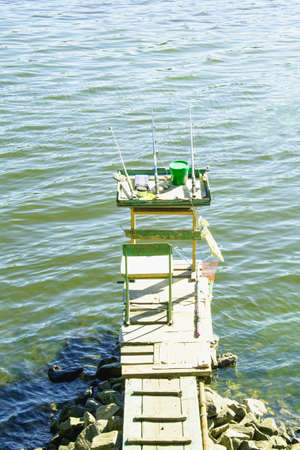 Fishing by a beautiful lake in summer on vacationの写真素材