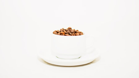White cup with coffee beans on a white, beautiful backgroundの写真素材