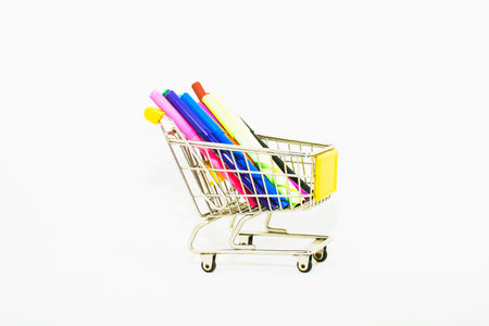 Shopping cart with colorful pens isolated on white background, business conceptの写真素材