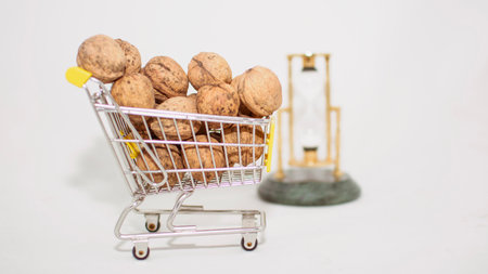 Walnuts in a shopping cart on a white background. The concept of shoppingの写真素材