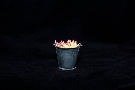 Pile of Matchsticks in a Black Bucket on a Black Backgroundの写真素材
