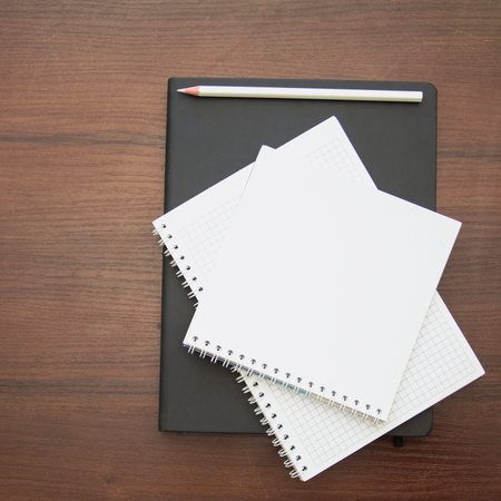 notebook and pencil on wood background, business and education concept.