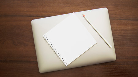 Notebook and pencil on wood table background. view from above.の写真素材