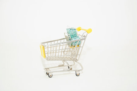 Shopping cart with gift boxes isolated on white background. Christmas shopping concept.の写真素材