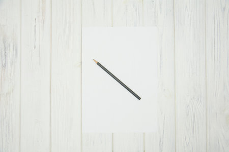 Pencil on a white sheet of paper on a white wooden backgroundの写真素材
