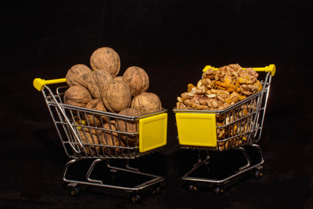 Walnuts and hazelnuts in a shopping cart. Black background.