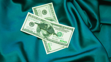 Dollars on blue satin fabric background. top view.の写真素材