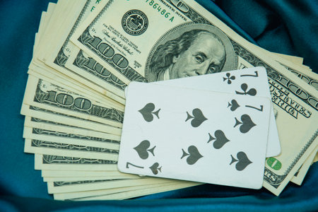 Playing cards and money on blue fabric background. selective focus.の写真素材