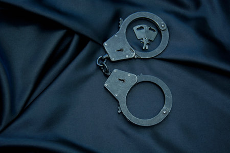 handcuffs on a black satin background, close-upの写真素材