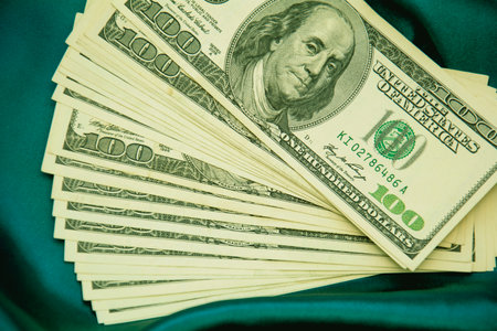 Dollar banknotes on green satin background. Shallow dof.の写真素材