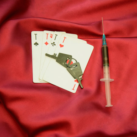 Syringe and poker cards on red satin background. top viewの写真素材