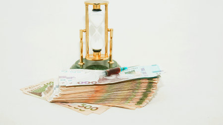 Time is money concept with hourglass and banknotes on white backgroundの写真素材
