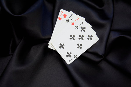 Playing cards on black satin background with copy space for your text