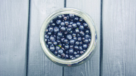 Fresh picked blueberries in a jar on a rustic wooden backgroundの写真素材