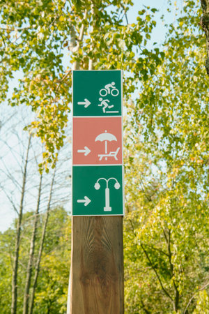 Directional signs in a park with trees in the background.の写真素材