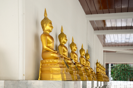 Row of golden buddha statue at Wat Pathum Wanaram, Bangkok, Thailand.の写真素材