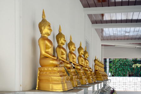 Row of golden buddha statue at Wat Pathum Wanaram, Bangkok, Thailand.