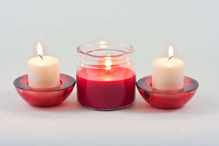 Set of three candles with flame and red ribbonの写真素材