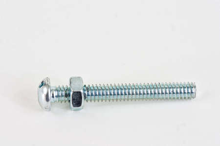 A long bolt with a screw almost to the top on a white background.の写真素材