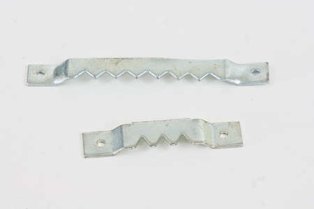 Two different sizes of saw thooth picture hangers on a white background.の写真素材