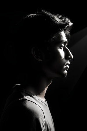 Portrait of a handsome asian young man looking away over black backgroundの素材