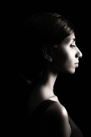 portrait of young beautiful woman on black background, monochromeの素材