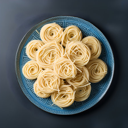 Pasta on a blue plate on a black background, top viewの素材
