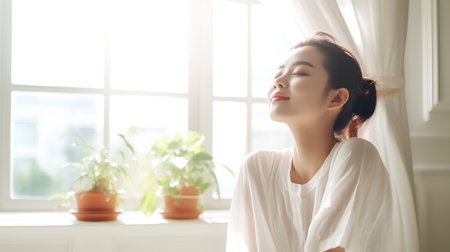 Beautiful asian woman relaxing in the room with a window view.の素材