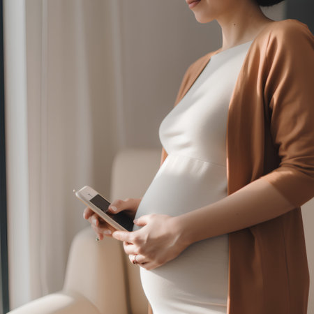 Pregnant woman using mobile phone in the living room at homeの素材