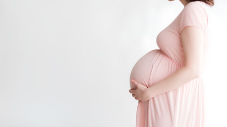 Pregnant woman touching her belly, isolated on white background.の素材
