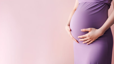 Pregnant woman in purple dress on pink background. Copy space.の素材