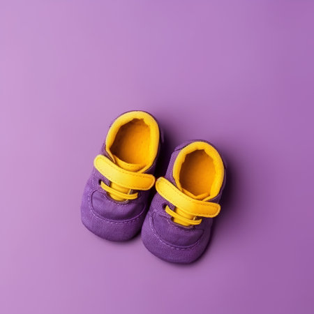 Baby shoes on purple background. Flat lay, top view, copy space.の素材