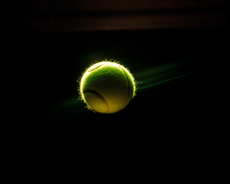 tennis ball on a dark background with a beam of light.の素材