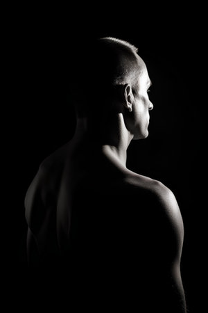 Portrait of a young muscular man on a black background. Studio shot.の素材