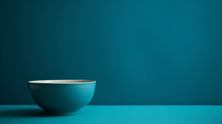 Empty bowl on turquoise background with copy space for your textの素材