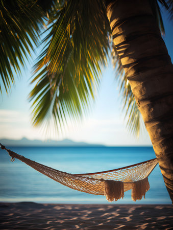 Hammock under palm tree on tropical beach at sunset. Vacation conceptの素材