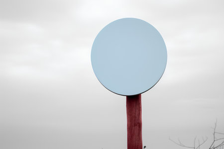 Blank blue sign on a red pole with a cloudy sky backgroundの素材
