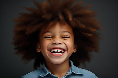 Cute little african american girl with afro hairstyle laughingの素材