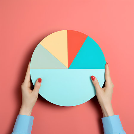 Woman hands holding pie chart circle on pink background. Top view.の素材