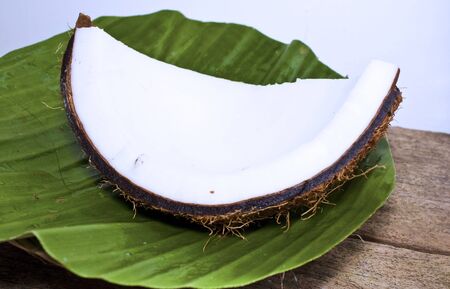 parts of the coconut in banana leaf  placed on the wood table 