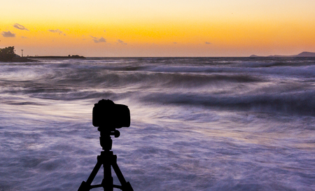 Camera on tripod with sea and sunset in background / Gouves, Crete, Greeceの写真素材