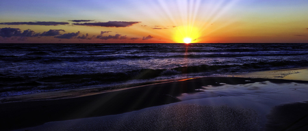 Sunset on Polish coast with visible sun rays - Baltic Sea in Lubiatowo, Pomorskie, Poland