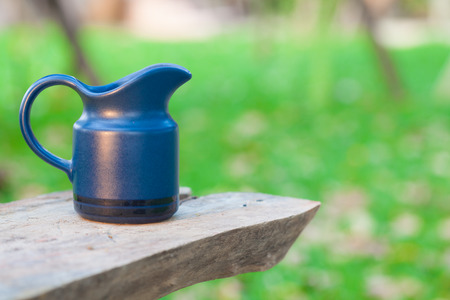 coffee jug on blur garden backgroundの写真素材