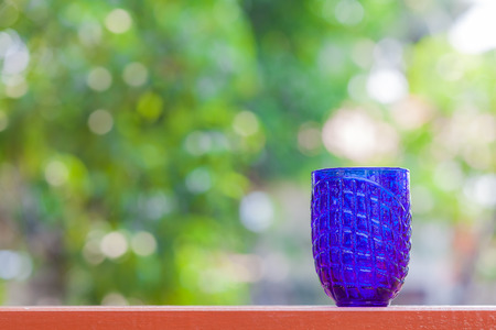 blue glass on blur garden backgroundの写真素材